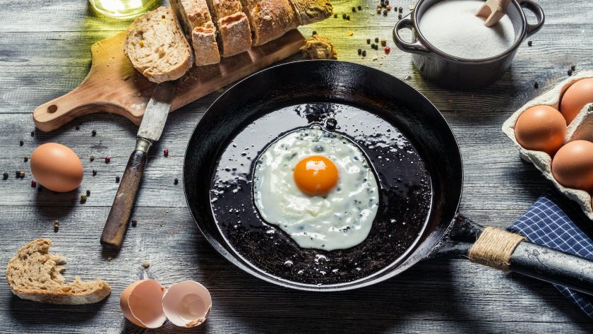 Fried egg on a pan and served with bread