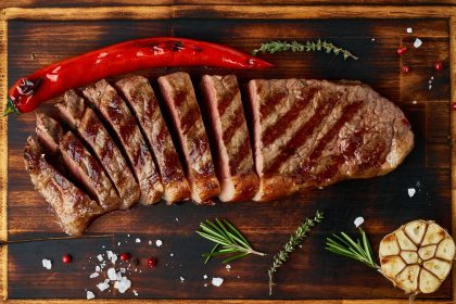 Keto ketogenic diet medium beef steak, grilled striploin on cutting board. Paleo food