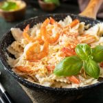 Mediterranean cuisine, seafood diet. Pasta farfalle with grilled shrimps bechamel sauce.