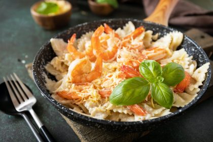 Mediterranean cuisine, seafood diet. Pasta farfalle with grilled shrimps bechamel sauce.